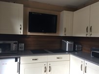 Kitchen area with 32" LCD TV, full sized fridge